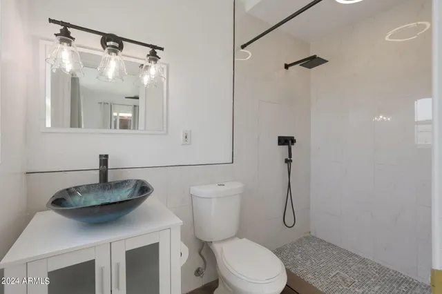 a bathroom with a granite countertop sink toilet and a mirror