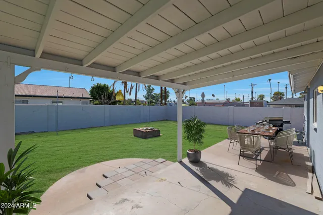 a view of a backyard with table and chairs and potted plants