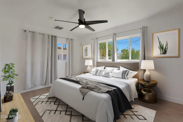 a bedroom with a bed and a painting on the wall