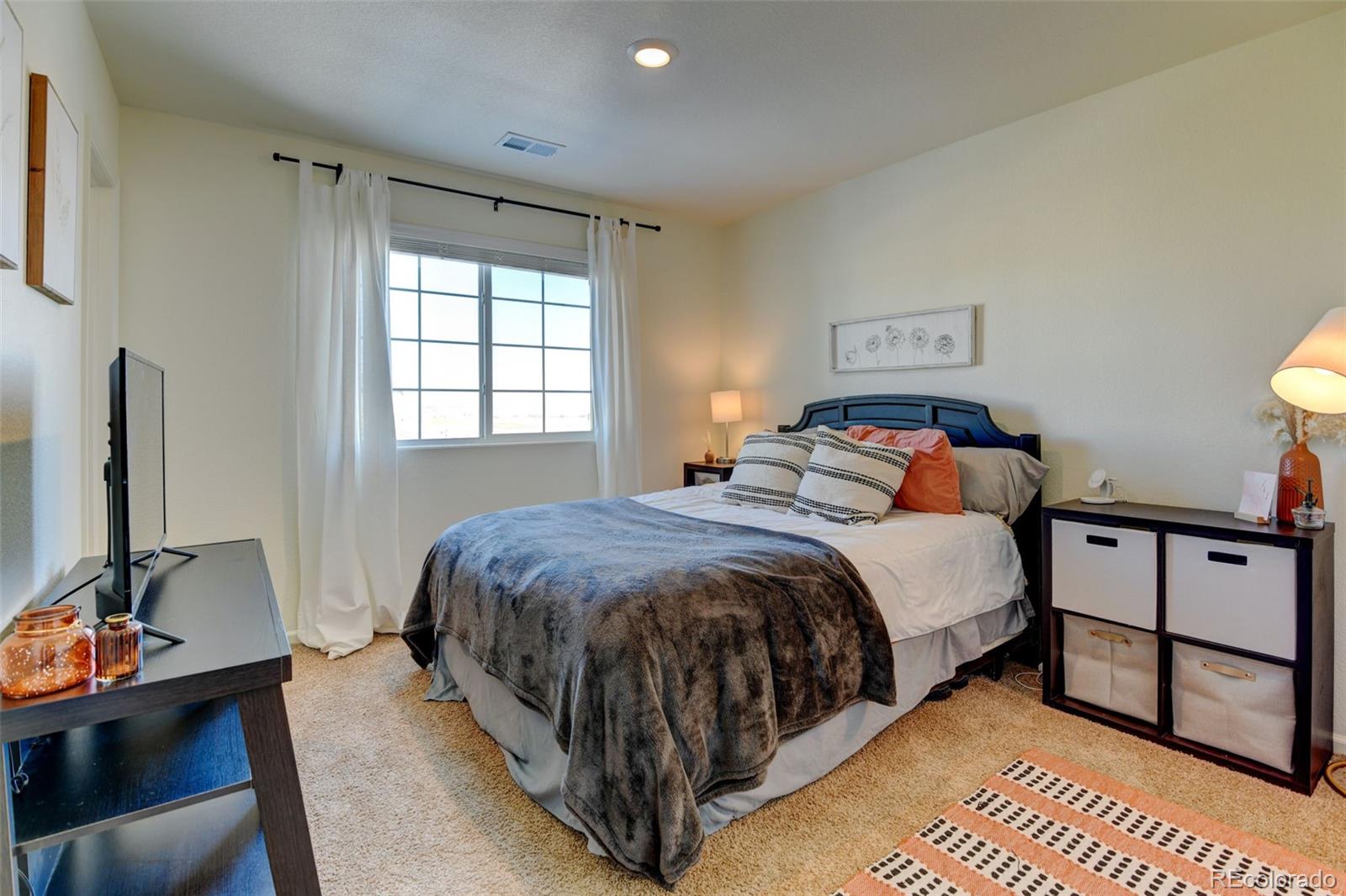 7252 Fall River Circle Frederick, CO 80530 - Photo 21 of 31 a spacious bedroom with a bed and a flat screen tv