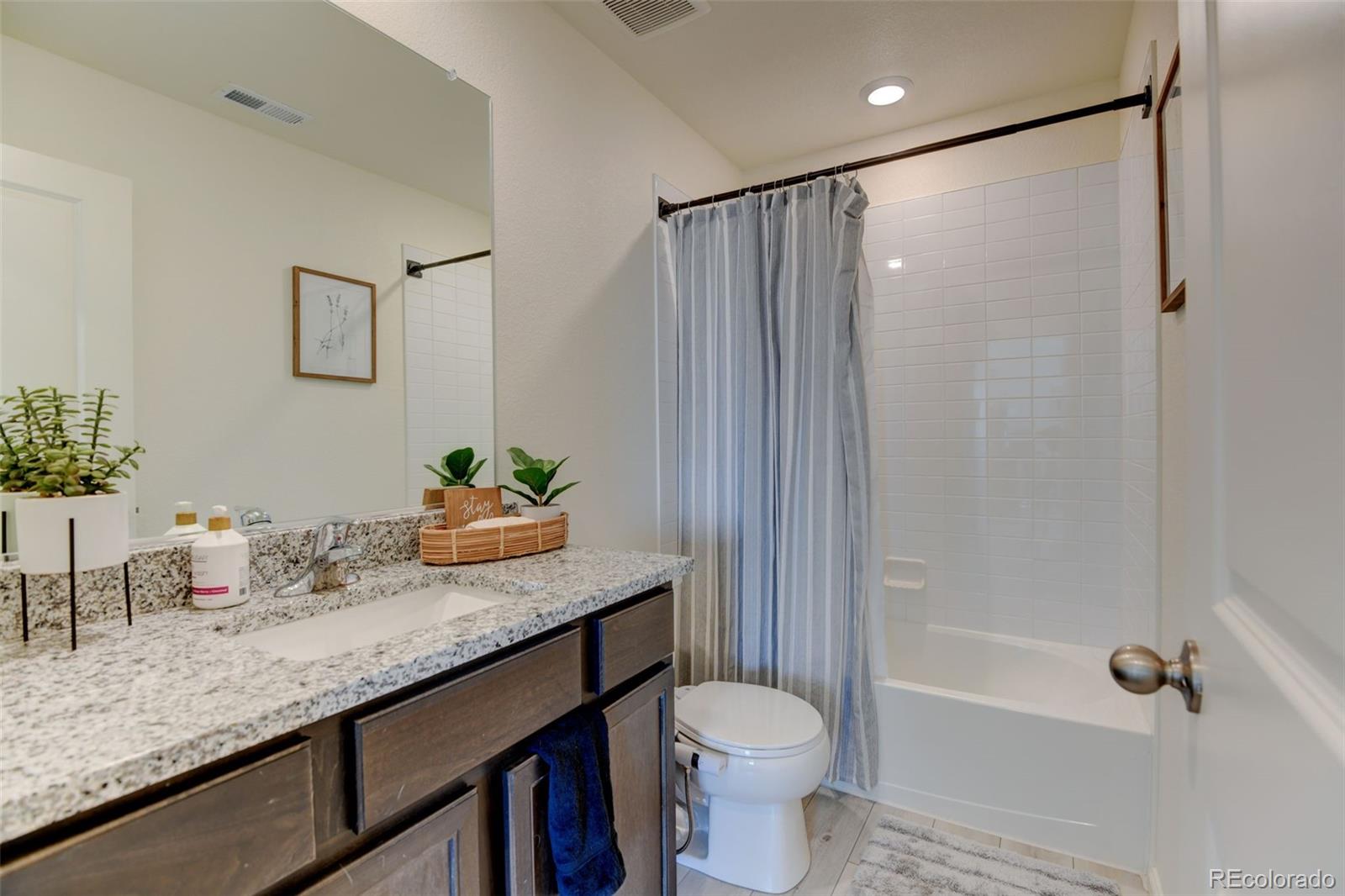 7252 Fall River Circle Frederick, CO 80530 - Photo 22 of 31 a bathroom with a granite countertop sink a toilet and shower