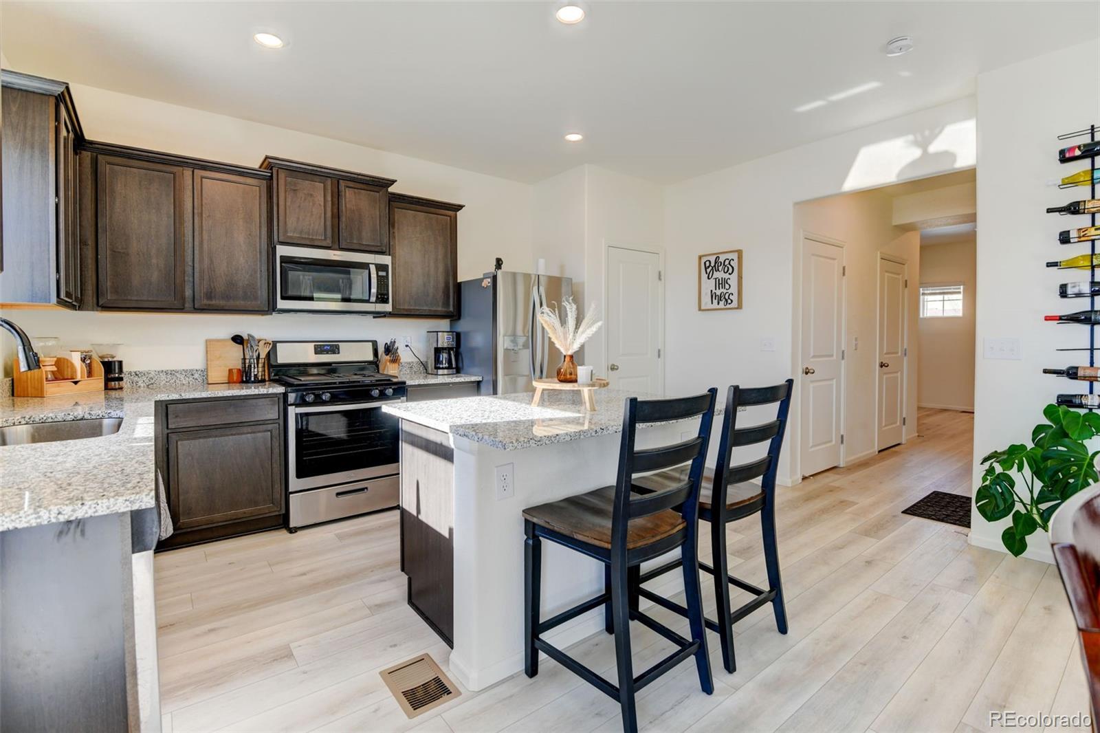 7252 Fall River Circle Frederick, CO 80530 - Photo 8 of 31 a kitchen with stainless steel appliances a microwave a stove a sink a refrigerator and chairs
