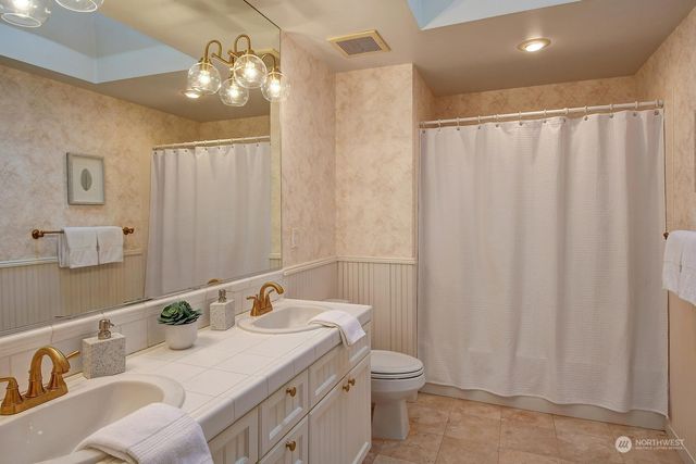 a bathroom with a double vanity sink and a mirror