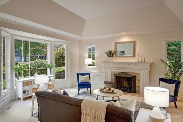 a living room with furniture a fireplace and a large window