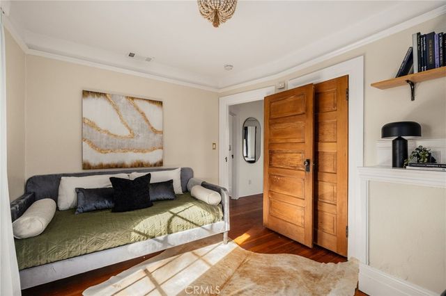 a bedroom with a bed mirror and window