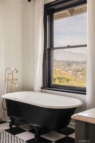 a kitchen with stainless steel appliances a dining table chairs refrigerator and cabinets