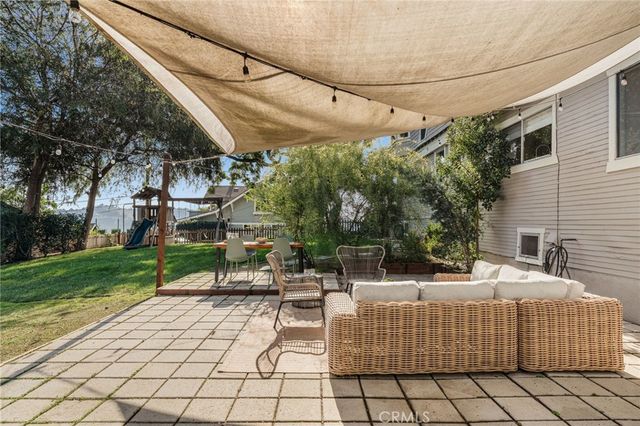 a view of a patio with couches table and chairs and potted plants