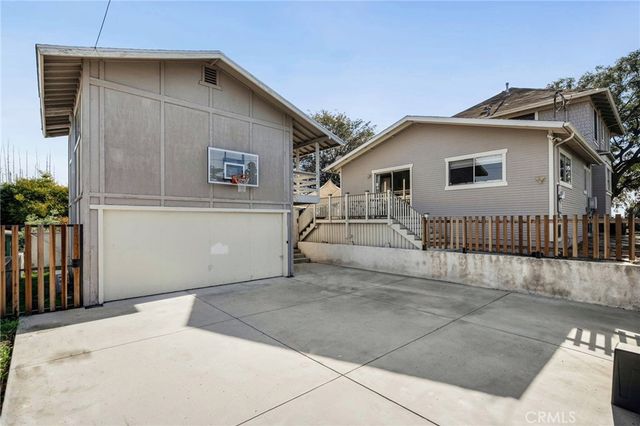 an aerial view of a house with a yard and large tree