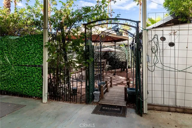a view of patio with chairs and table under an umbrella