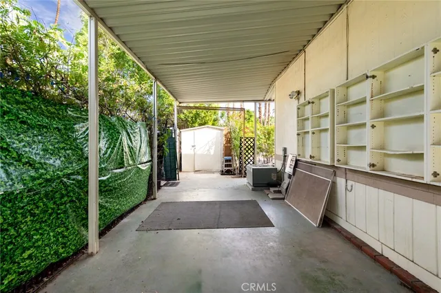 a view of a porch with couches potted plants and floor to ceiling window