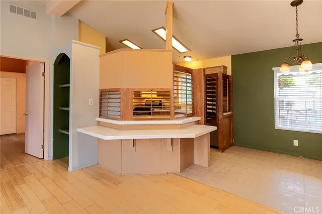 a view of a kitchen with kitchen island a sink stainless steel appliances and cabinets