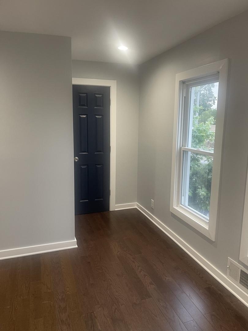 48 East 154th Street Harvey, IL 60426 - Photo 13 of 20 an empty room with wooden floor and windows