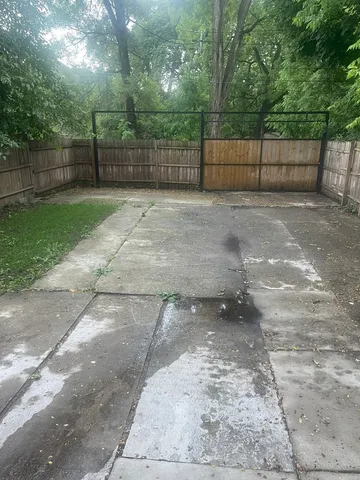 a view of a backyard with a fence and trees