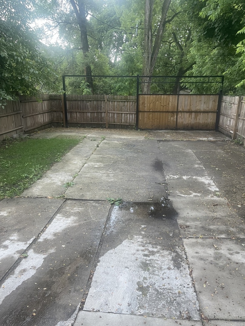 48 East 154th Street Harvey, IL 60426 - Photo 20 of 20 a view of a backyard with a fence and trees