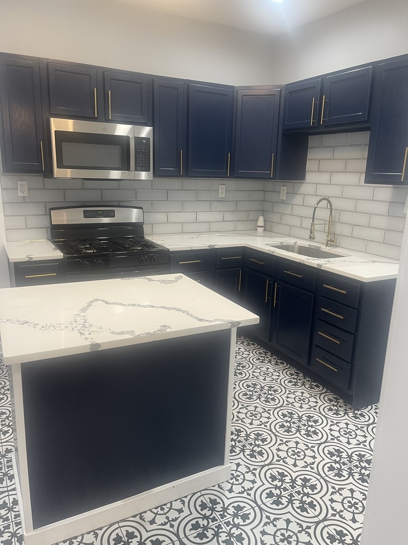 48 East 154th Street Harvey, IL 60426 - Photo 4 of 20 a kitchen with a sink and a stove top oven