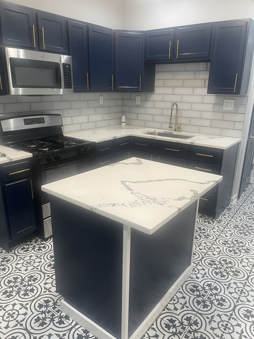 48 East 154th Street Harvey, IL 60426 - Photo 6 of 20 a kitchen with stainless steel appliances kitchen island granite countertop a sink stove and microwave