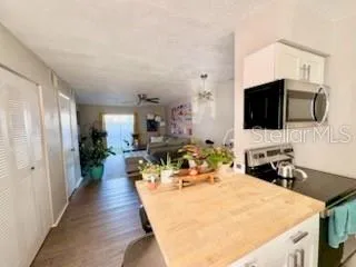 a living room with furniture a flat screen tv and a refrigerator