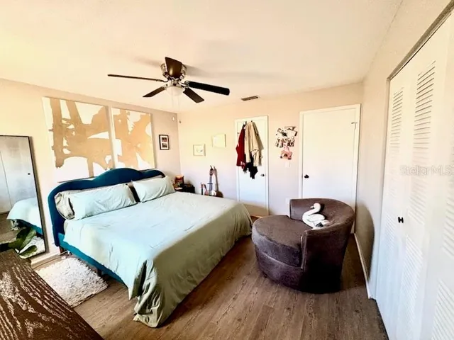 a bedroom with a bed and wooden floor