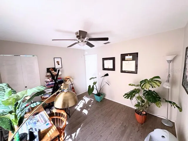 a living room with furniture flowers and a potted plant