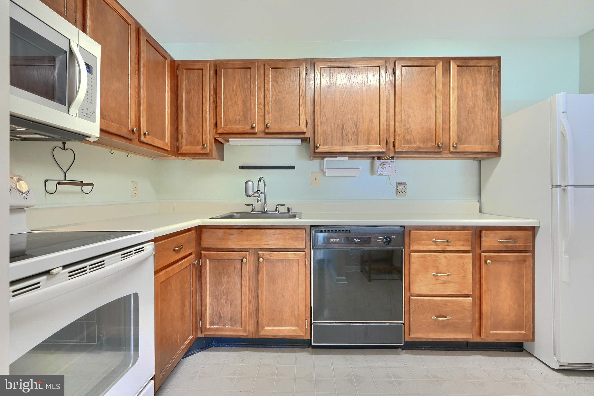 4102 Chardel Road, Unit 2H Nottingham, MD 21236 - Photo 6 of 21 a kitchen with stainless steel appliances granite countertop white cabinets sink and a granite counter top