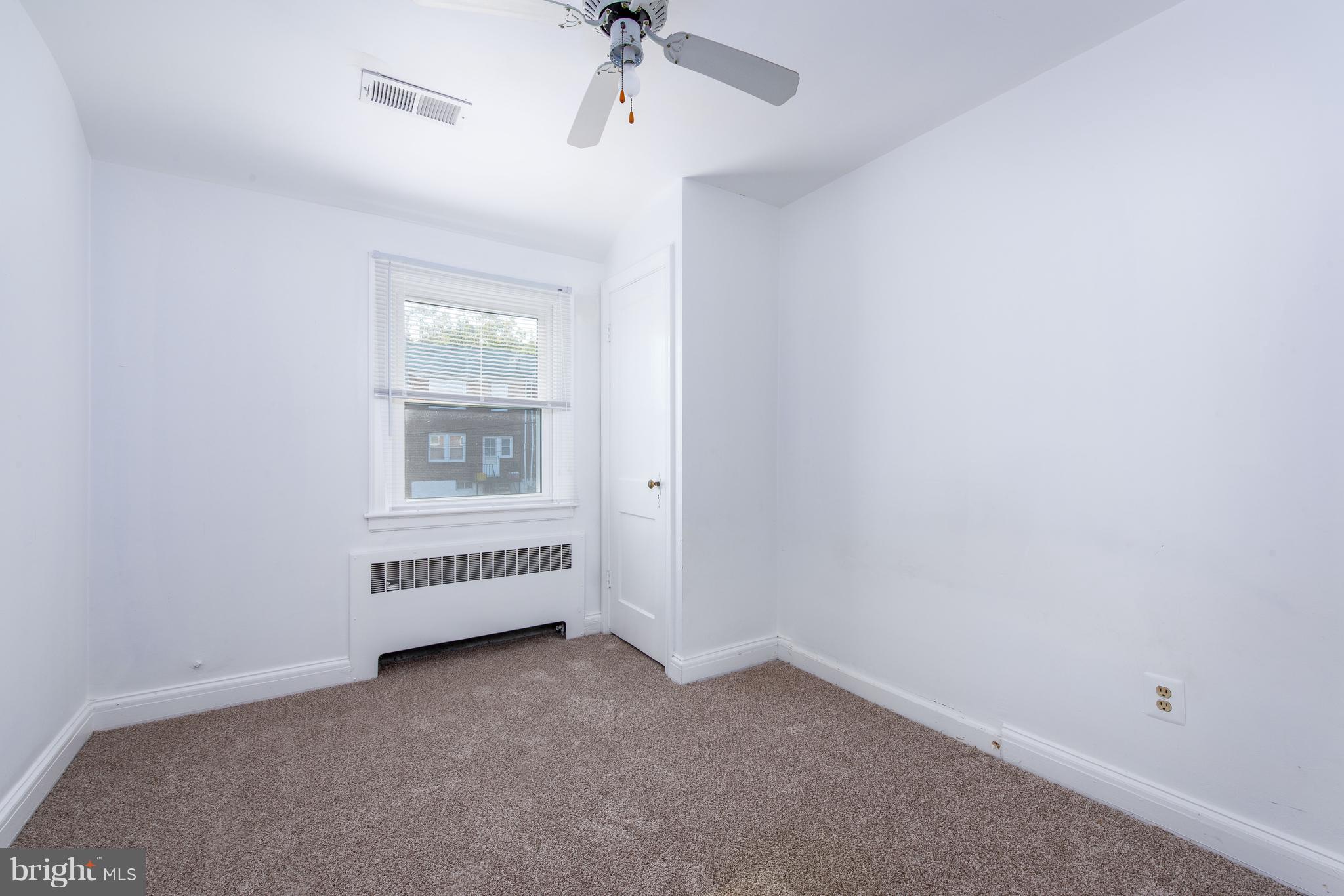 3818 Rexmere Road Baltimore, MD 21218 - Photo 12 of 25 an empty room with a ceiling fan and windows