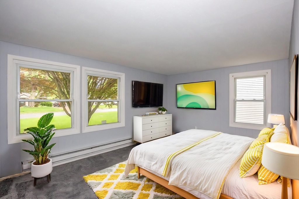 1101 Allen Street Springfield, MA 01118 - Photo 21 of 29 a bedroom with a bed a flat screen tv and a potted plant