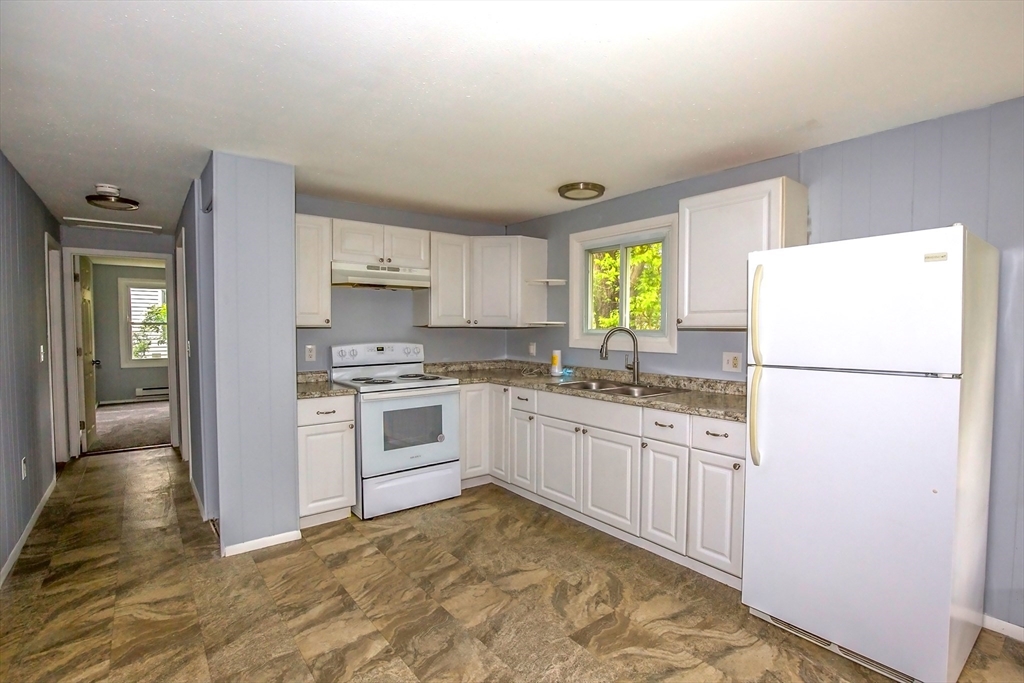1101 Allen Street Springfield, MA 01118 - Photo 3 of 29 a kitchen with granite countertop a refrigerator a stove a sink a dining table and chairs