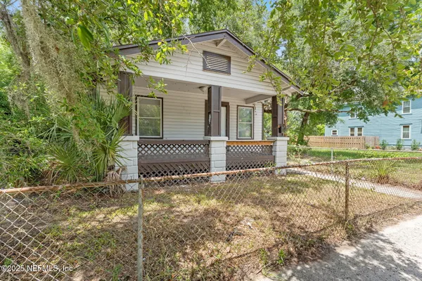 a view of a house with a yard and fence