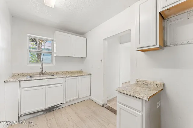 a kitchen with granite countertop a sink and cabinets