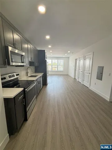 a large kitchen with stainless steel appliances wooden floors and wooden cabinets