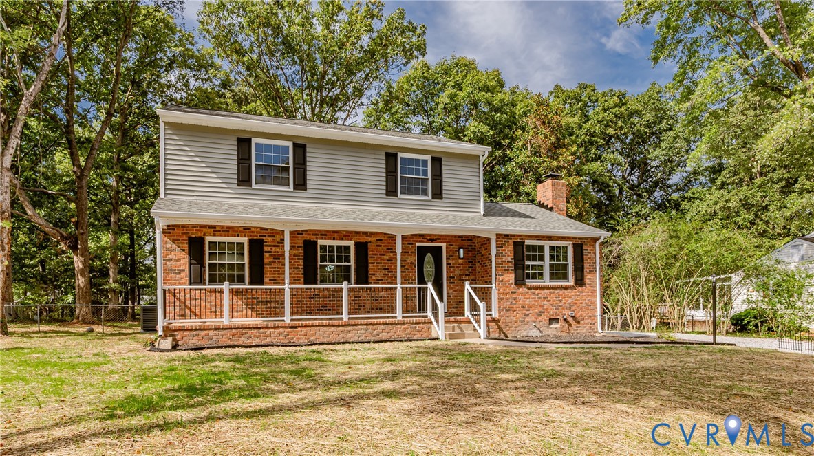 Traditional home with a porch, brick siding, a chi