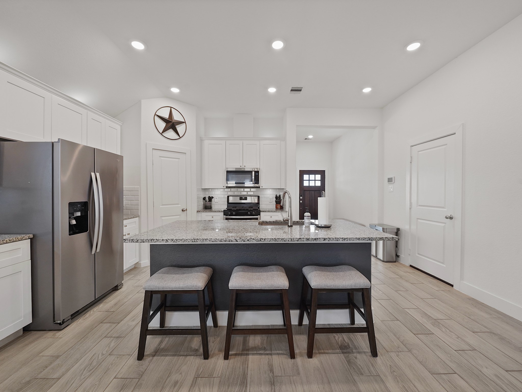 9 Alyssa Palms Drive Manvel, TX 77578 - Photo 7 of 30 a kitchen with stainless steel appliances a dining table chairs and wooden floor