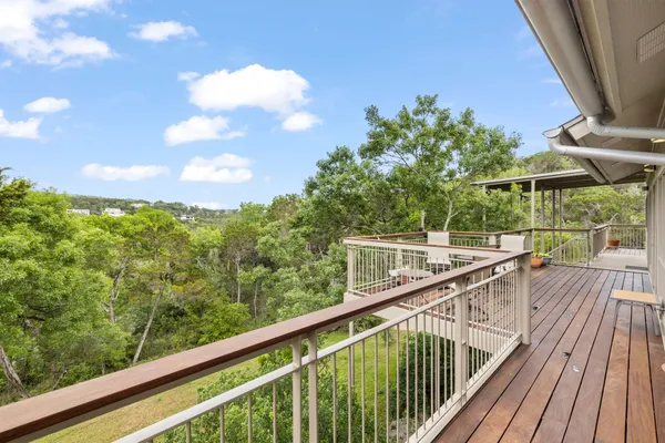 a view of a balcony with wooden floor and fence
