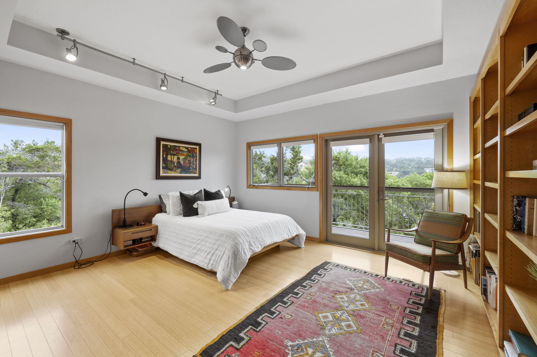 701 Yaupon Valley Road West Lake Hills, TX 78746 - Photo 15 of 40 The spacious primary suite feels like a treehouse retreat, featuring a wall of bookcases and ample space for a king-size bed.