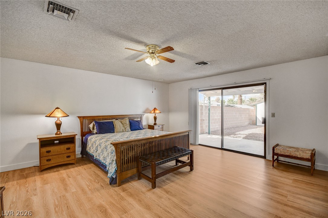 1401 Sharon Road Las Vegas, NV 89106 - Photo 53 of 73 Sliding glass doors open directly to the patio from this spacious bedroom with wood flooring.