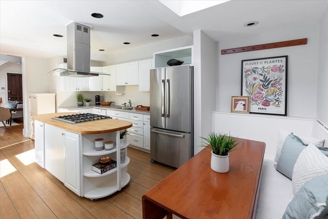 a kitchen with stainless steel appliances granite countertop a refrigerator a stove and a wooden floors