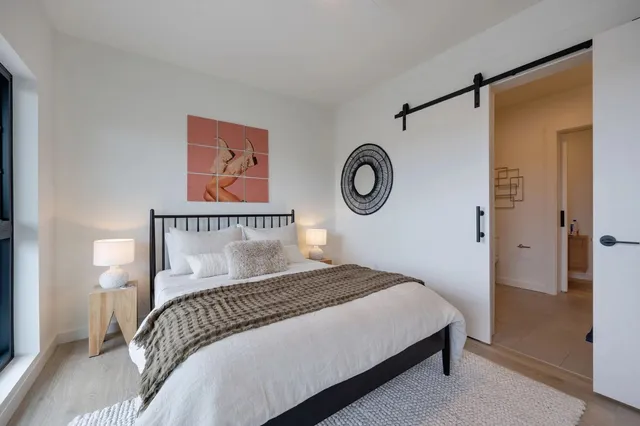 a bedroom with a bed and a painting on the wall