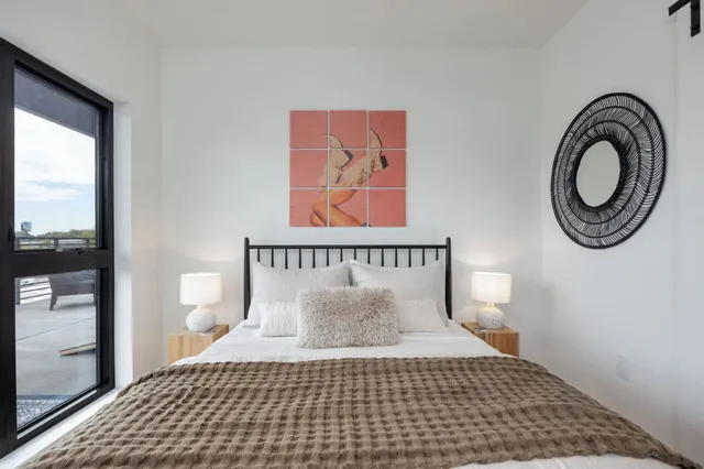 a bedroom with a bed and a tv on the wall