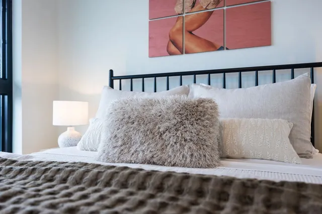 a bedroom with a bed and a painting on the wall