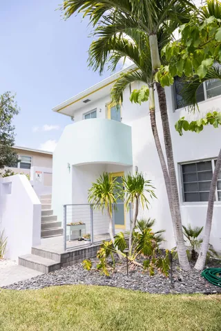 a vase of flowers sitting on a floor in front of a house