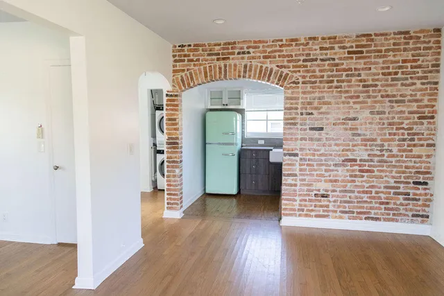a view of a hallway with wooden floor and a living room