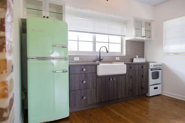 a room with a sink cabinets and a window