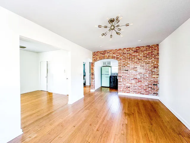 a view of an empty room with wooden floor