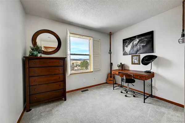 a bedroom with a bed and painting on the wall