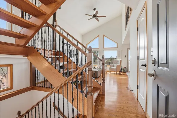 a view of staircase with lots of frames on wall and wooden floor