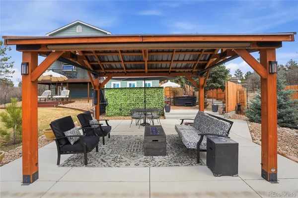 a view of a chairs and table in the patio along the house