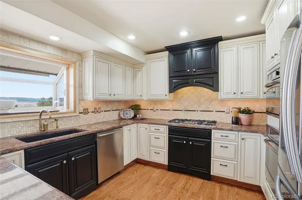 a kitchen with granite countertop a sink stainless steel appliances and cabinets