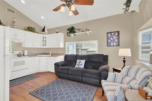 a living room with furniture a wooden floor and a chandelier