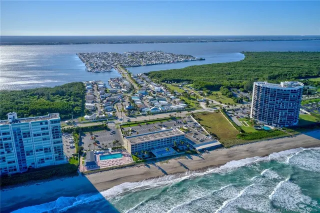 an aerial view of a tennis ground with large trees and houses