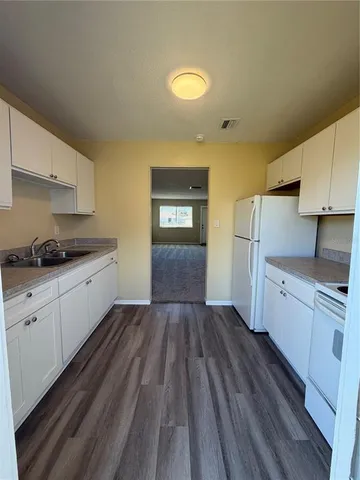 a kitchen with cabinets a sink and wooden floor